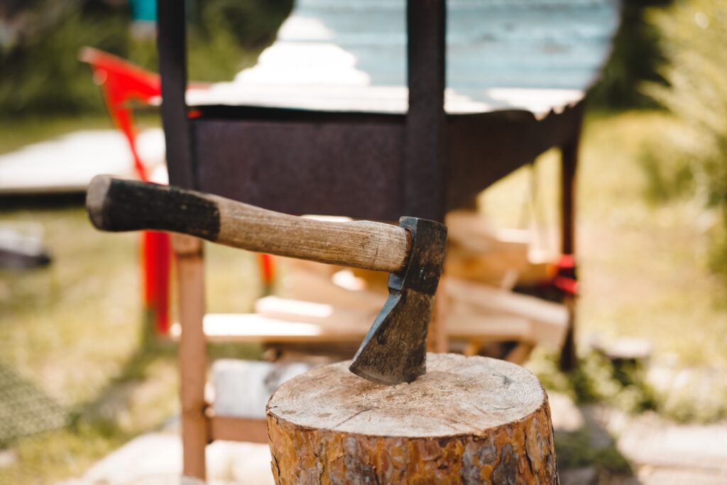 An axe stuck in a piece of wood.