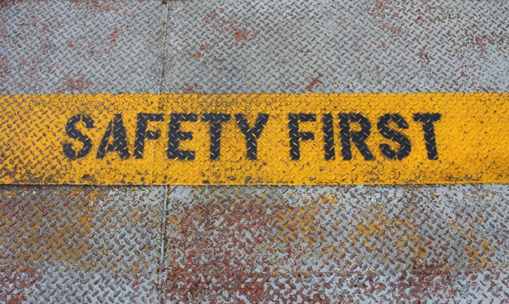 Words “safety first” written in black lettering on metal.