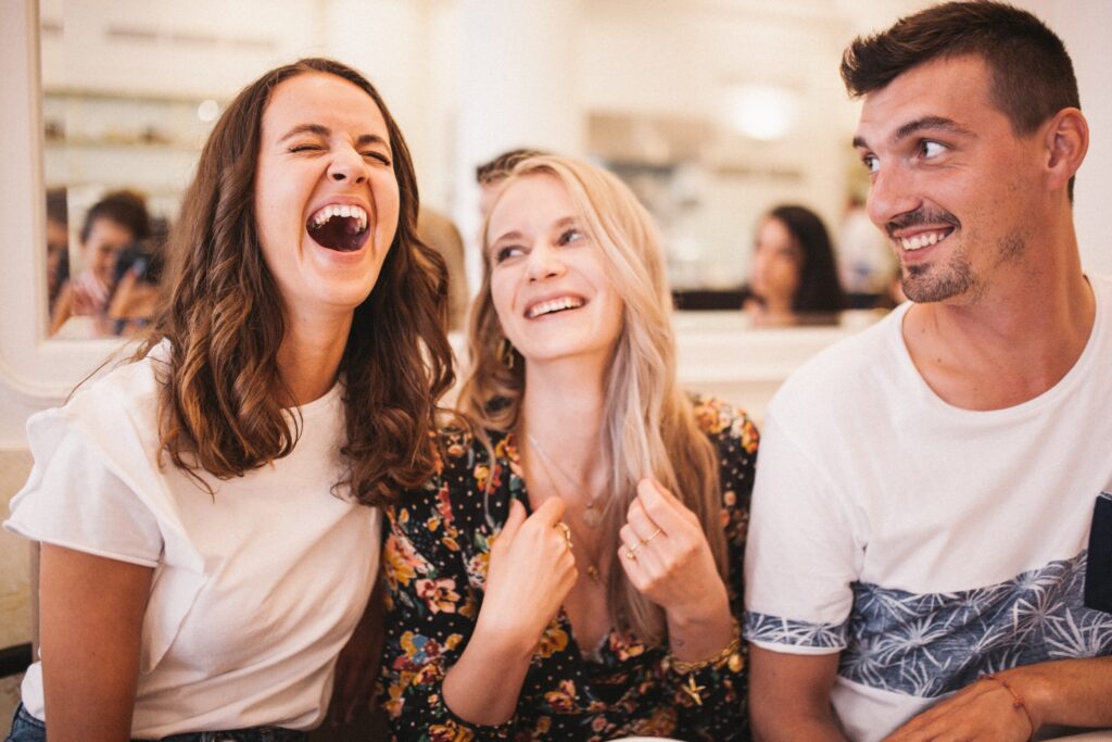 A group of three friends smiling and laughing.