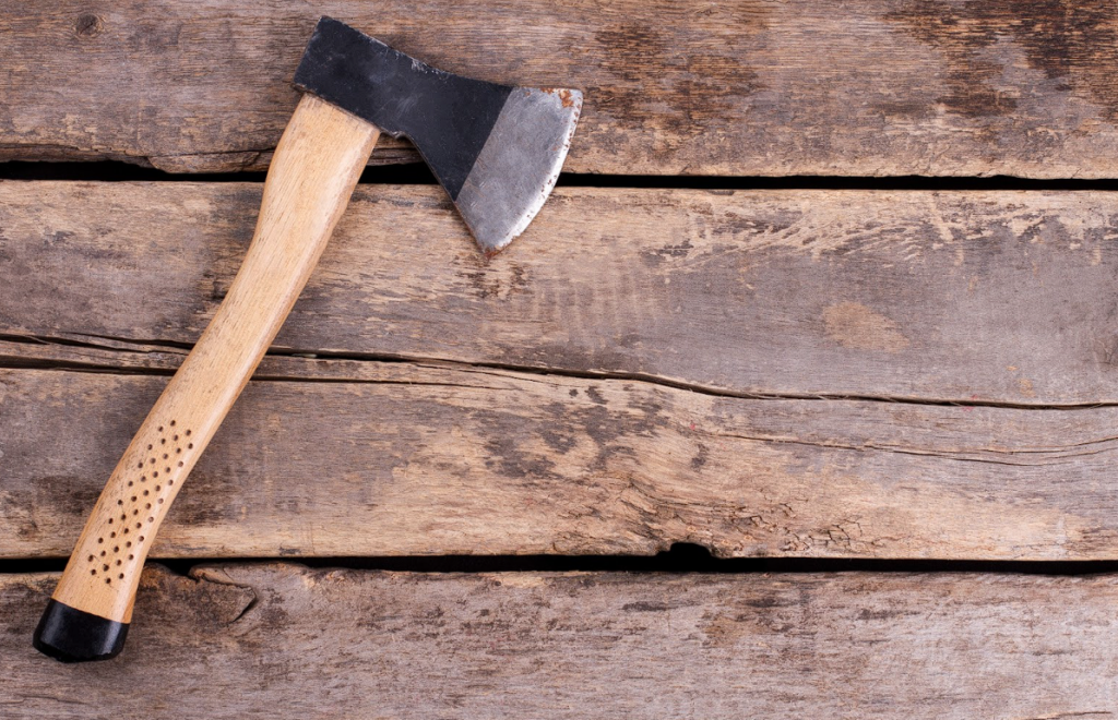 A top view of an axe on a rustic wood floor.